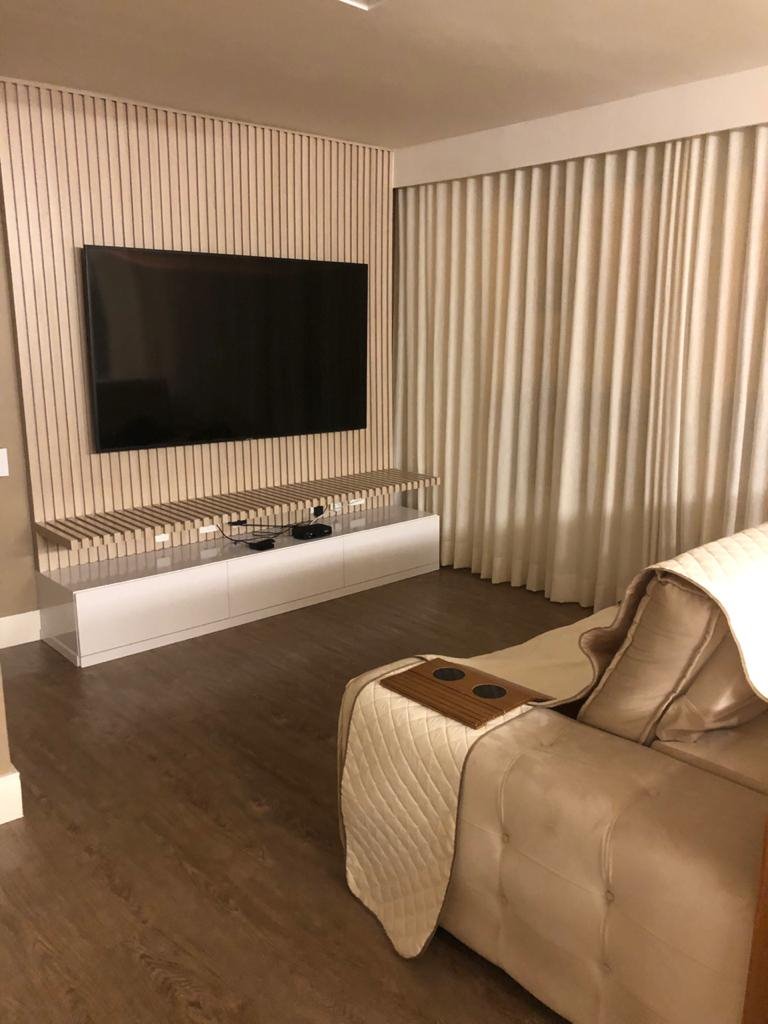 Sala com painel ripado e rack planejado para TV
